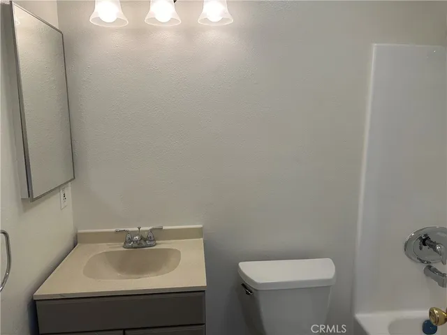 a bathroom with a sink toilet and mirror