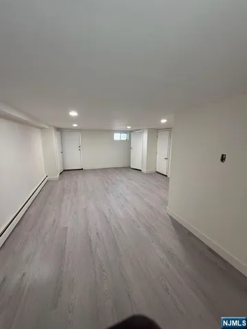 a view of a big room with wooden floor and windows