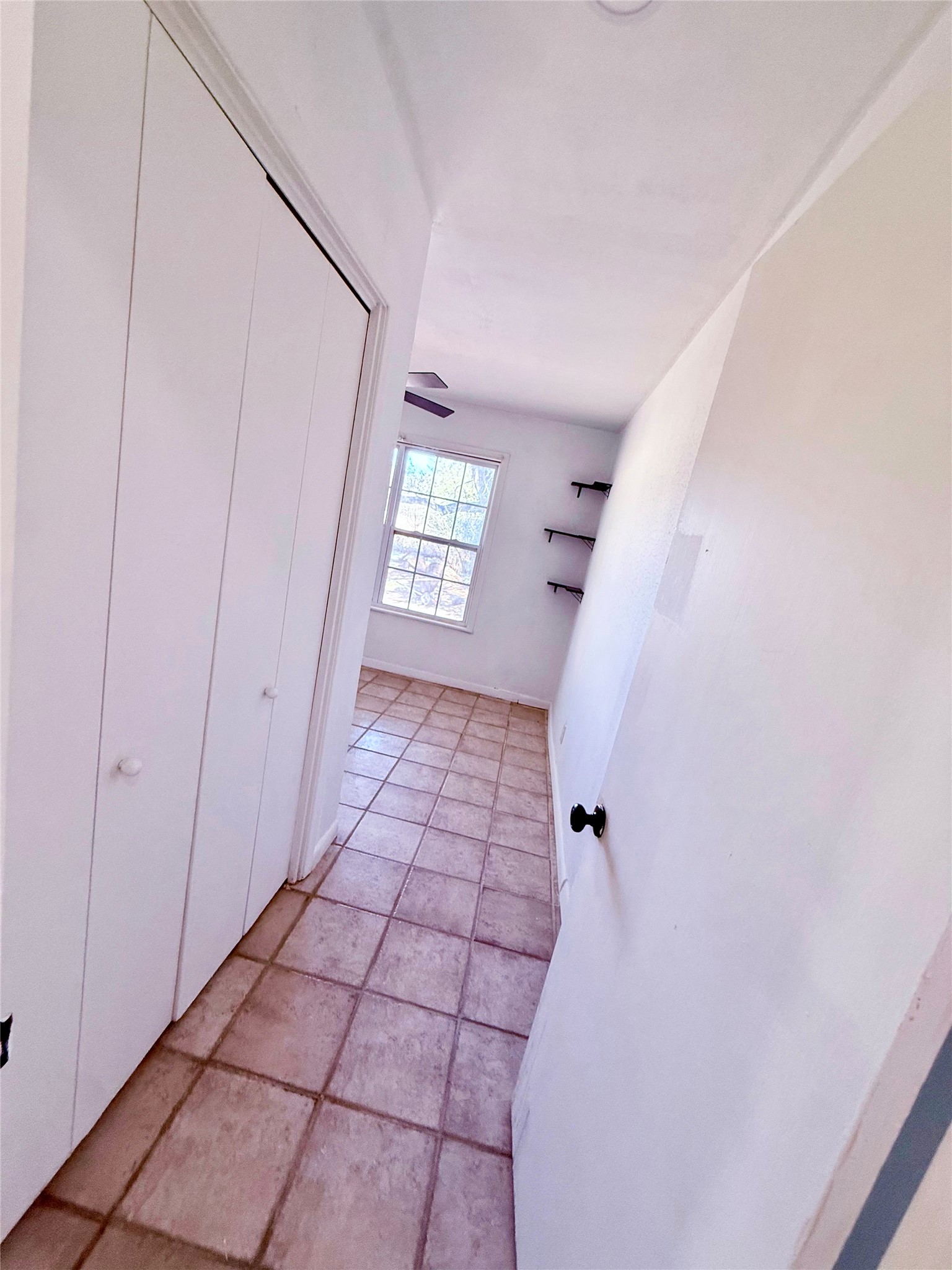 51 Hanging Oak Road Dale, TX 78616 - Photo 12 of 32 Hallway featuring square tile flooring and bi-fold closet doors