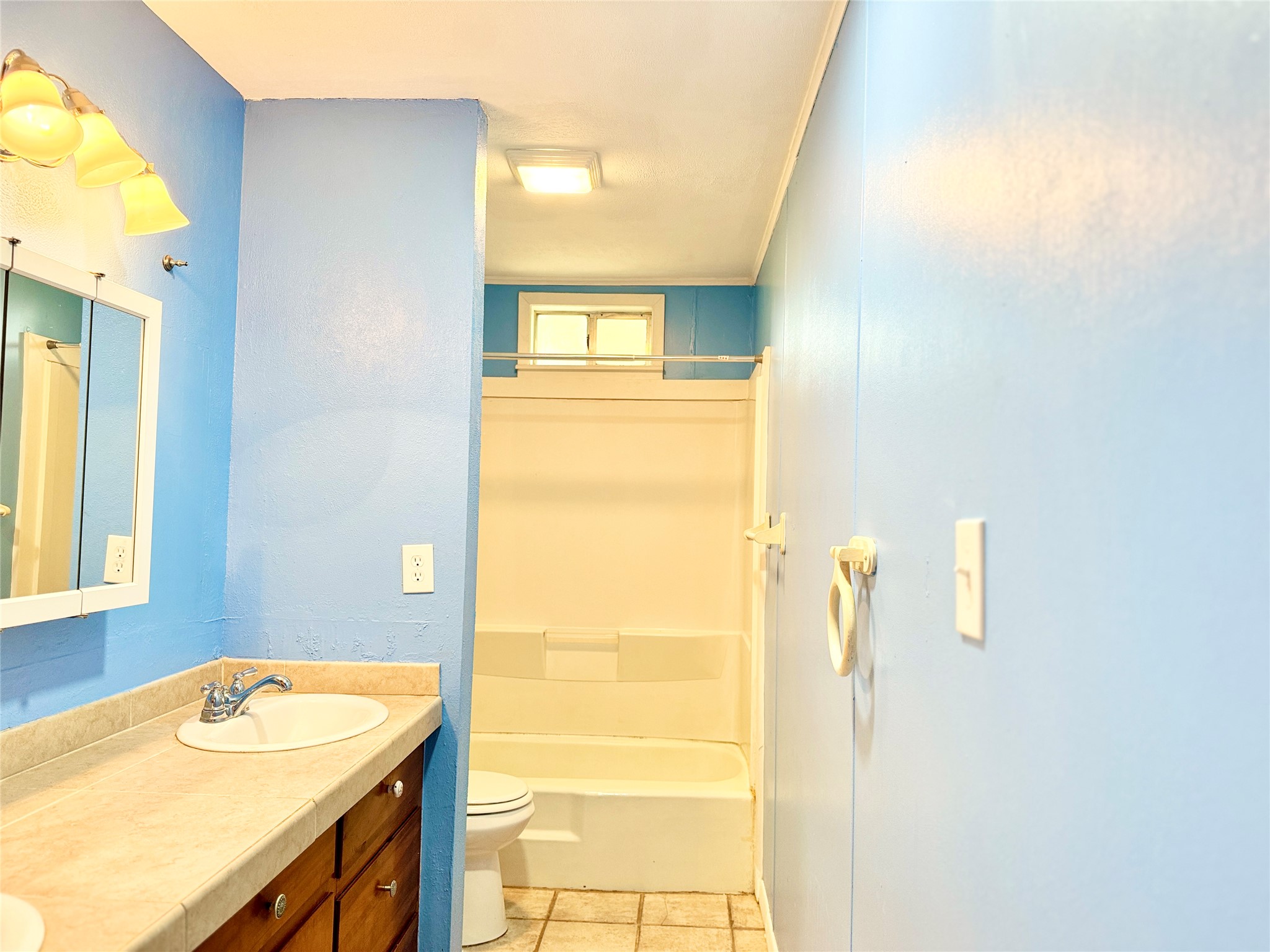 51 Hanging Oak Road Dale, TX 78616 - Photo 18 of 32 Bathroom featuring a vanity with an integrated sink, built-in wooden cabinetry, and a tile-look countertop