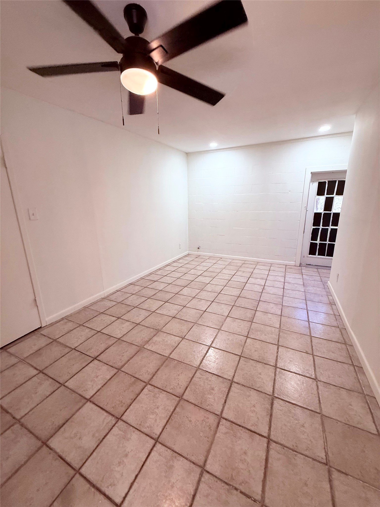 51 Hanging Oak Road Dale, TX 78616 - Photo 7 of 32 Spacious room featuring neutral tile flooring, a dark-toned ceiling fan with integrated lighting, and recessed ceiling lights