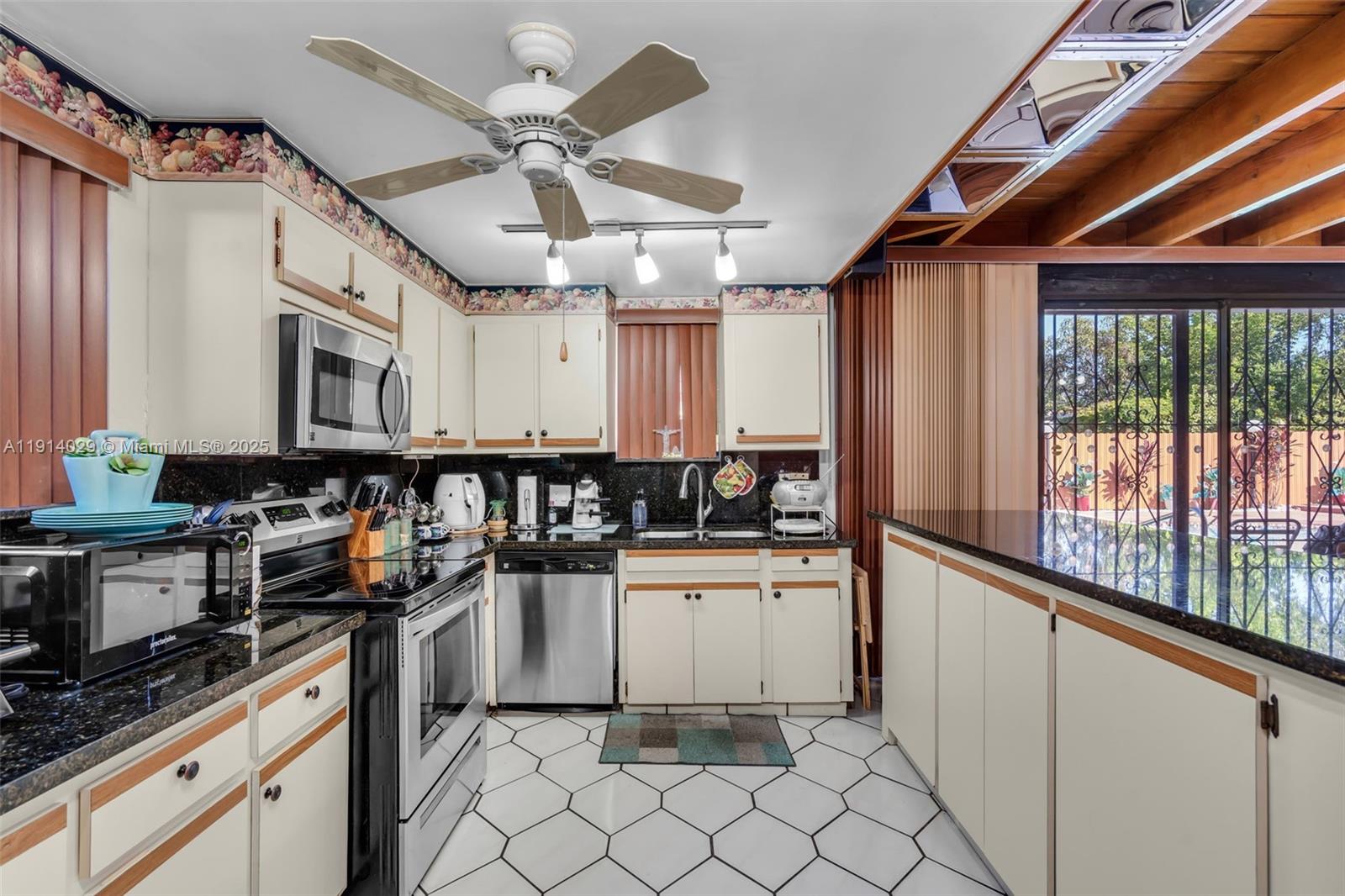 1861 Southwest 19th Street Miami, FL 33145 - Photo 16 of 38 a kitchen with granite countertop a stove a sink and a refrigerator