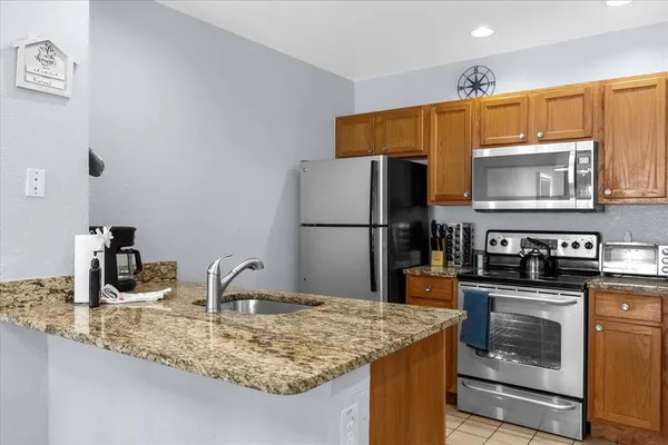a kitchen with stainless steel appliances granite countertop a sink stove and refrigerator