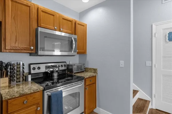 a kitchen with stainless steel appliances granite countertop a sink stove and microwave