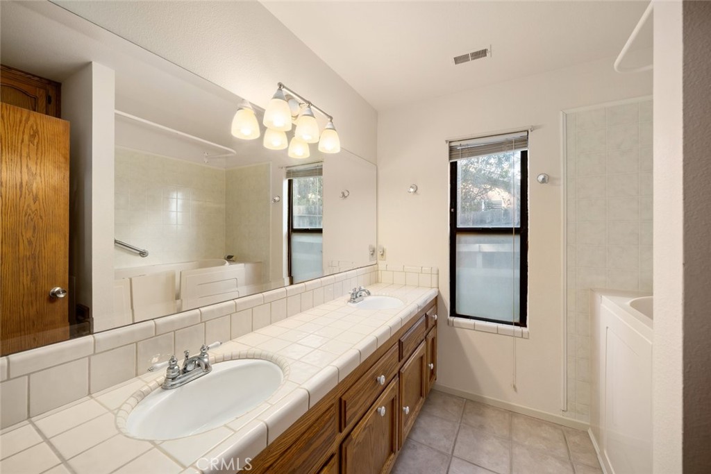 261 Hazel Lane Nipomo, CA 93444 - Photo 22 of 68 a spacious bathroom with a double vanity sink and a mirror
