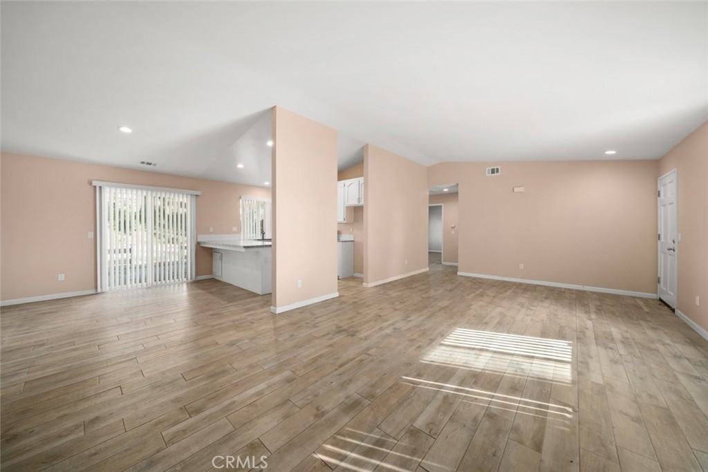 261 Hazel Lane Nipomo, CA 93444 - Photo 37 of 68 a view of an empty room with wooden floor and a kitchen