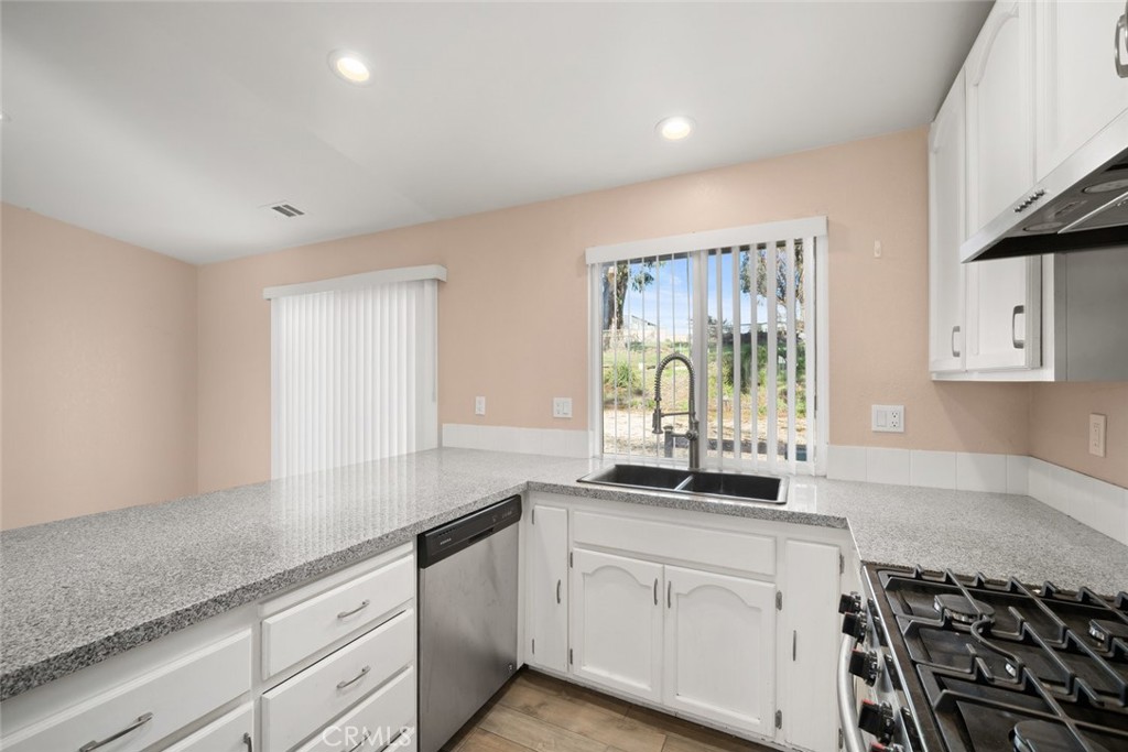 261 Hazel Lane Nipomo, CA 93444 - Photo 40 of 68 a kitchen with granite countertop a sink and a stove