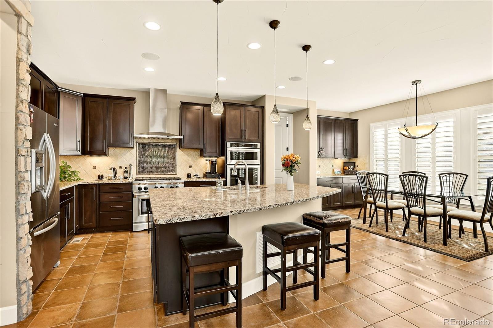 10544 Soulmark Way Highlands Ranch, CO 80126 - Photo 12 of 50 a large kitchen with a table and chairs