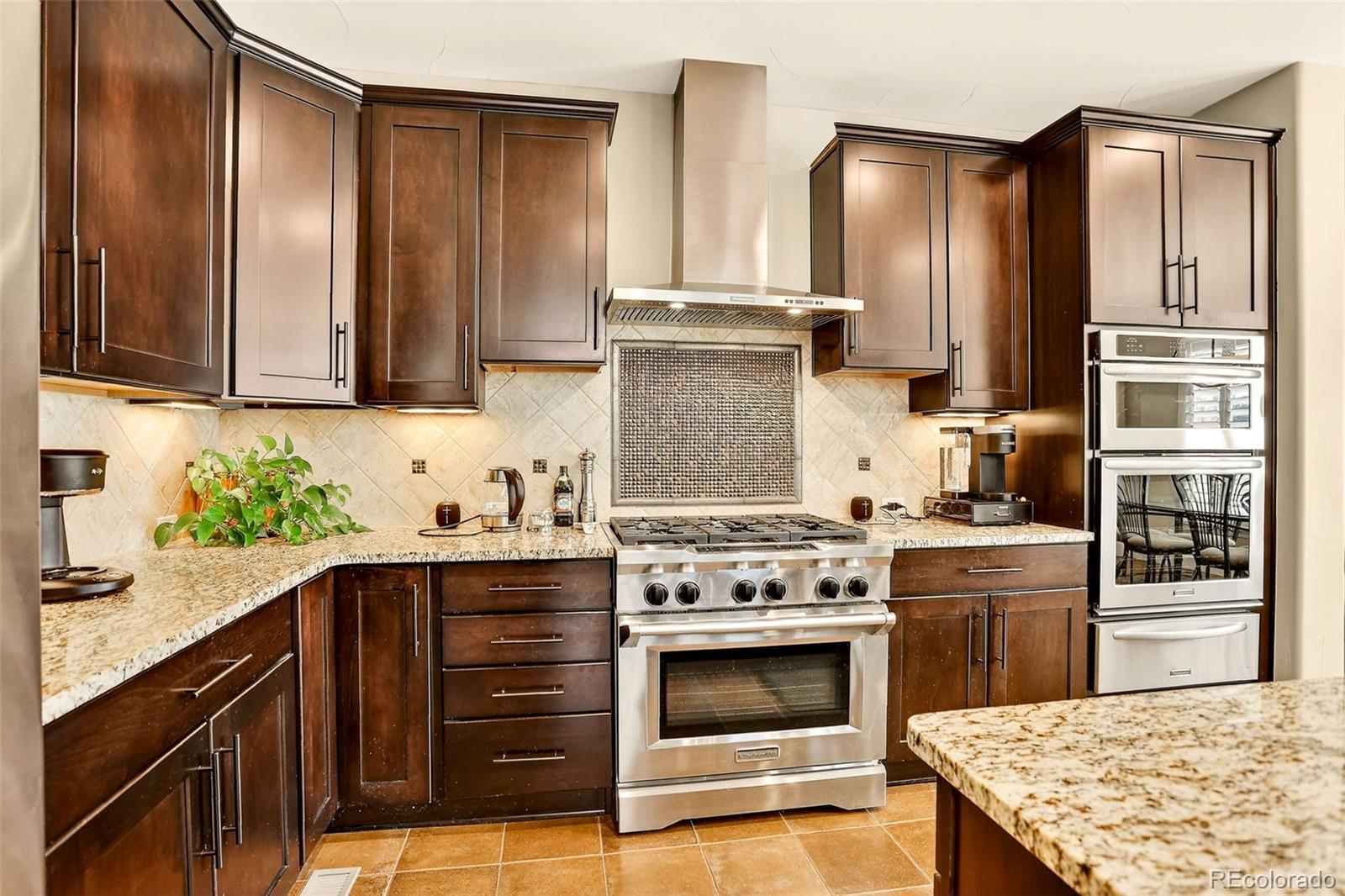 10544 Soulmark Way Highlands Ranch, CO 80126 - Photo 13 of 50 a kitchen with stainless steel appliances granite countertop wooden cabinets a stove top oven a sink and dishwasher