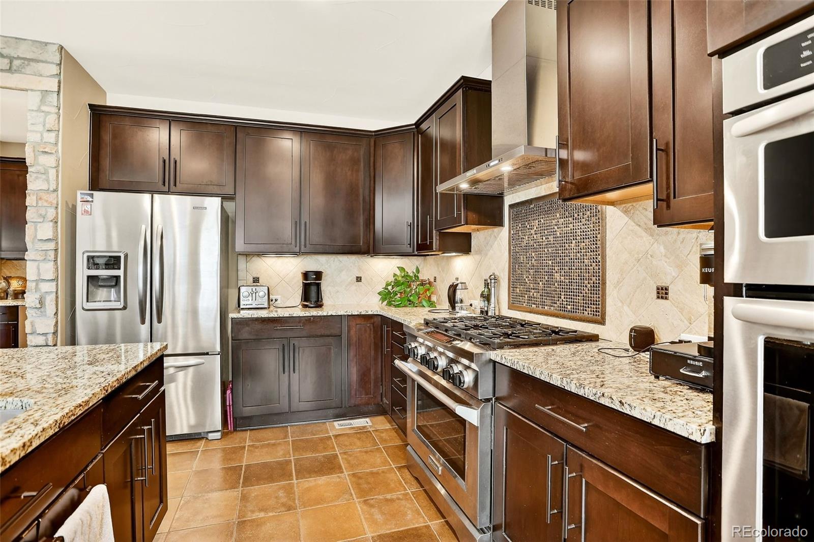 10544 Soulmark Way Highlands Ranch, CO 80126 - Photo 14 of 50 a kitchen with stainless steel appliances granite countertop a stove a sink and a refrigerator