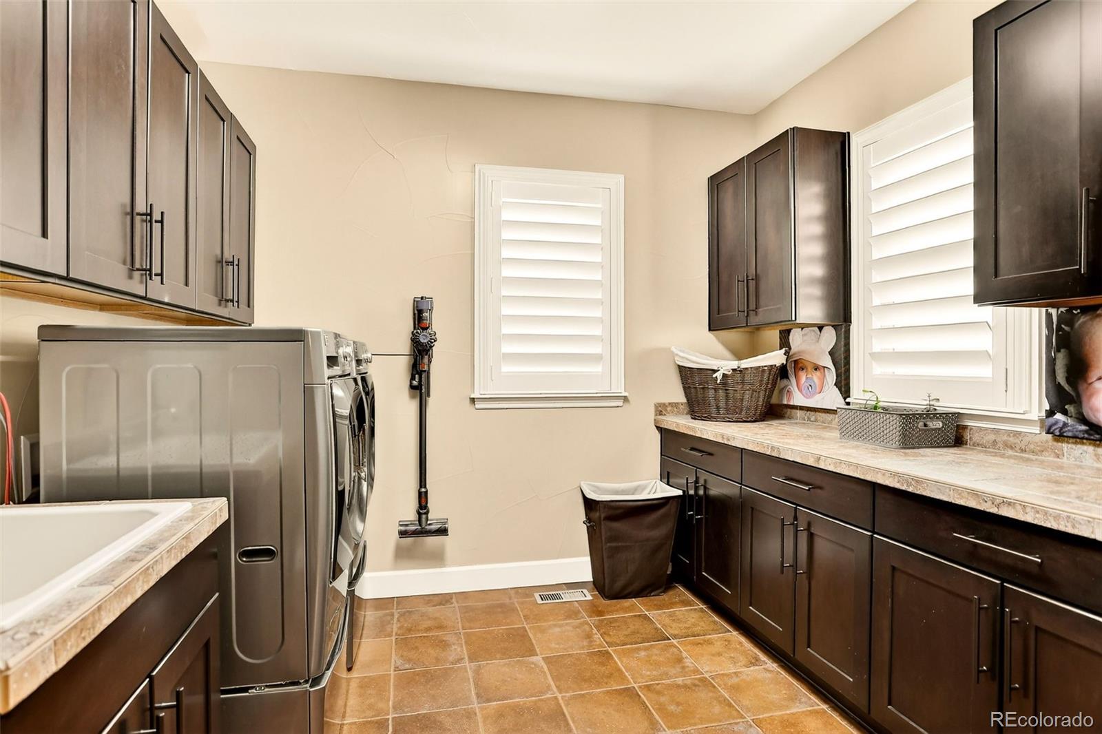 10544 Soulmark Way Highlands Ranch, CO 80126 - Photo 18 of 50 a kitchen with a sink a refrigerator and cabinets