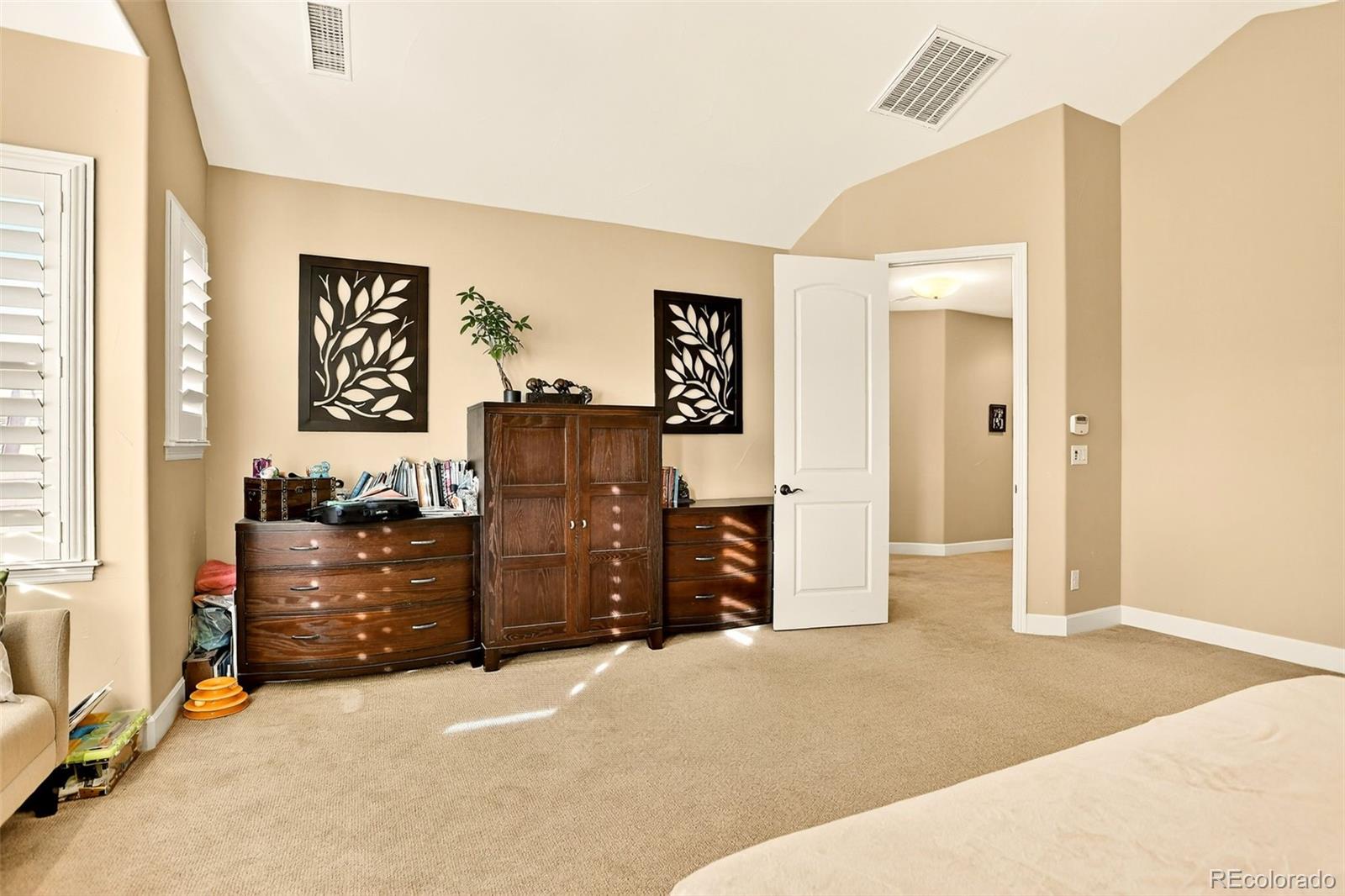 10544 Soulmark Way Highlands Ranch, CO 80126 - Photo 27 of 50 a bedroom with a dresser and mirror