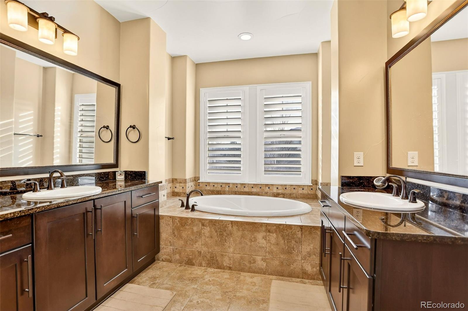 10544 Soulmark Way Highlands Ranch, CO 80126 - Photo 28 of 50 a spacious bathroom with sinks mirror and a bathtub