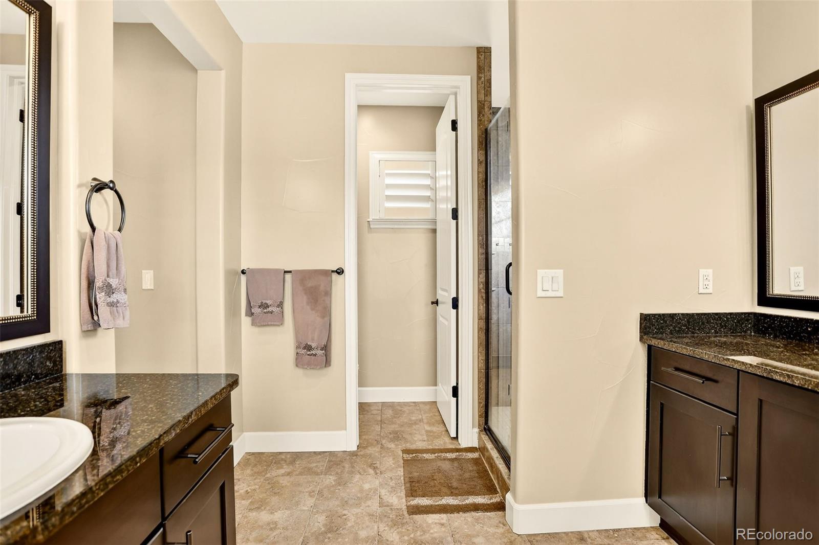 10544 Soulmark Way Highlands Ranch, CO 80126 - Photo 29 of 50 a bathroom with a granite countertop sink and a mirror