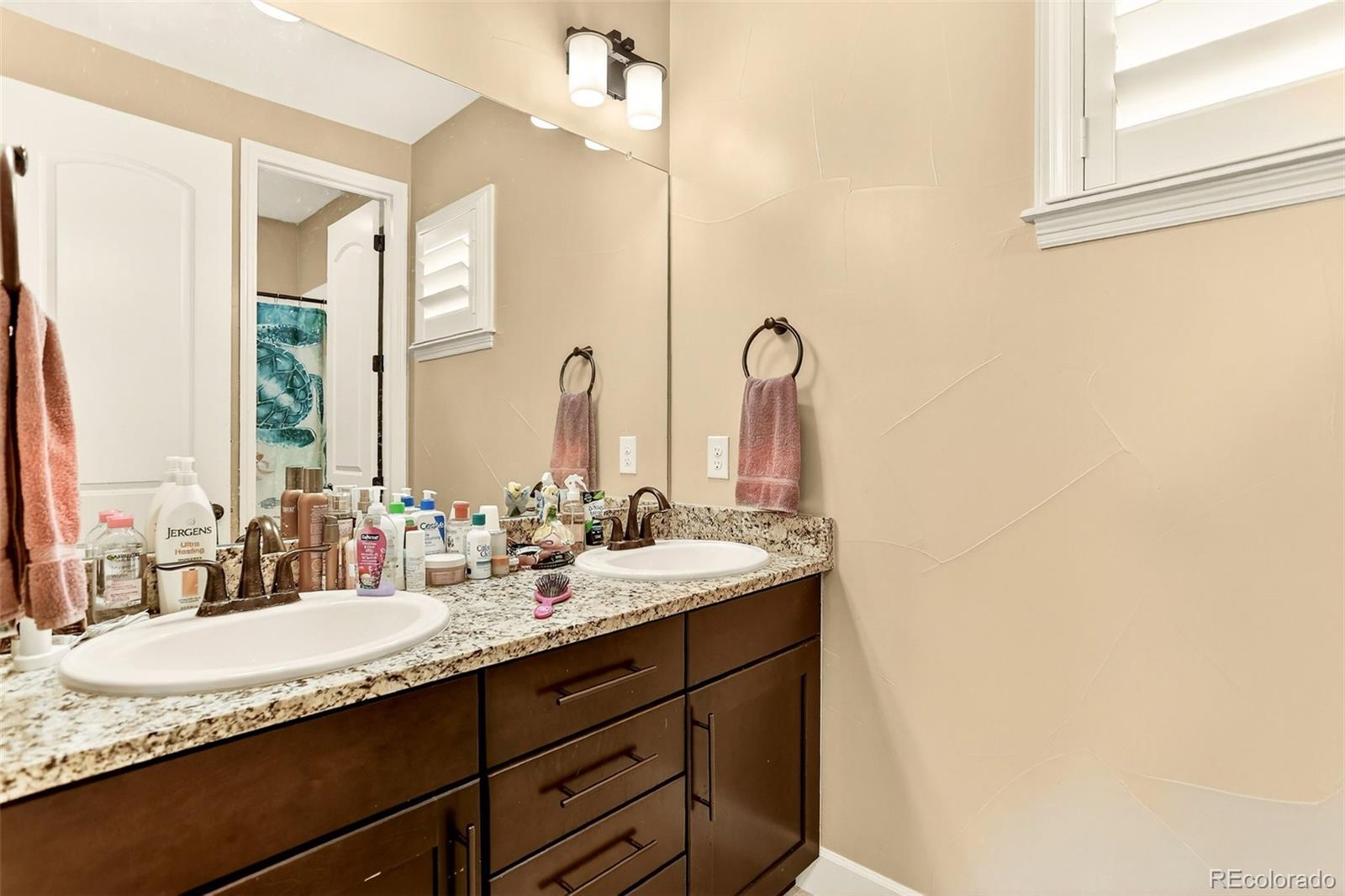 10544 Soulmark Way Highlands Ranch, CO 80126 - Photo 35 of 50 a bathroom with double sink and a mirror