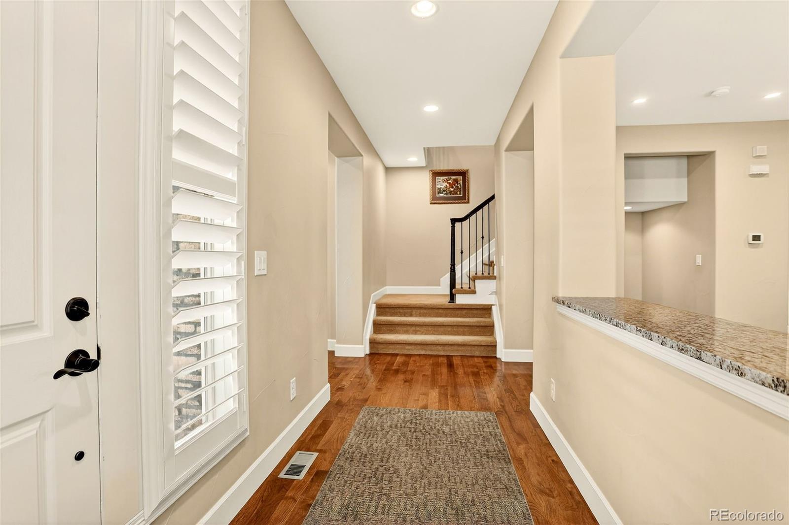 10544 Soulmark Way Highlands Ranch, CO 80126 - Photo 4 of 50 a view of a hallway with wooden floor and staircase