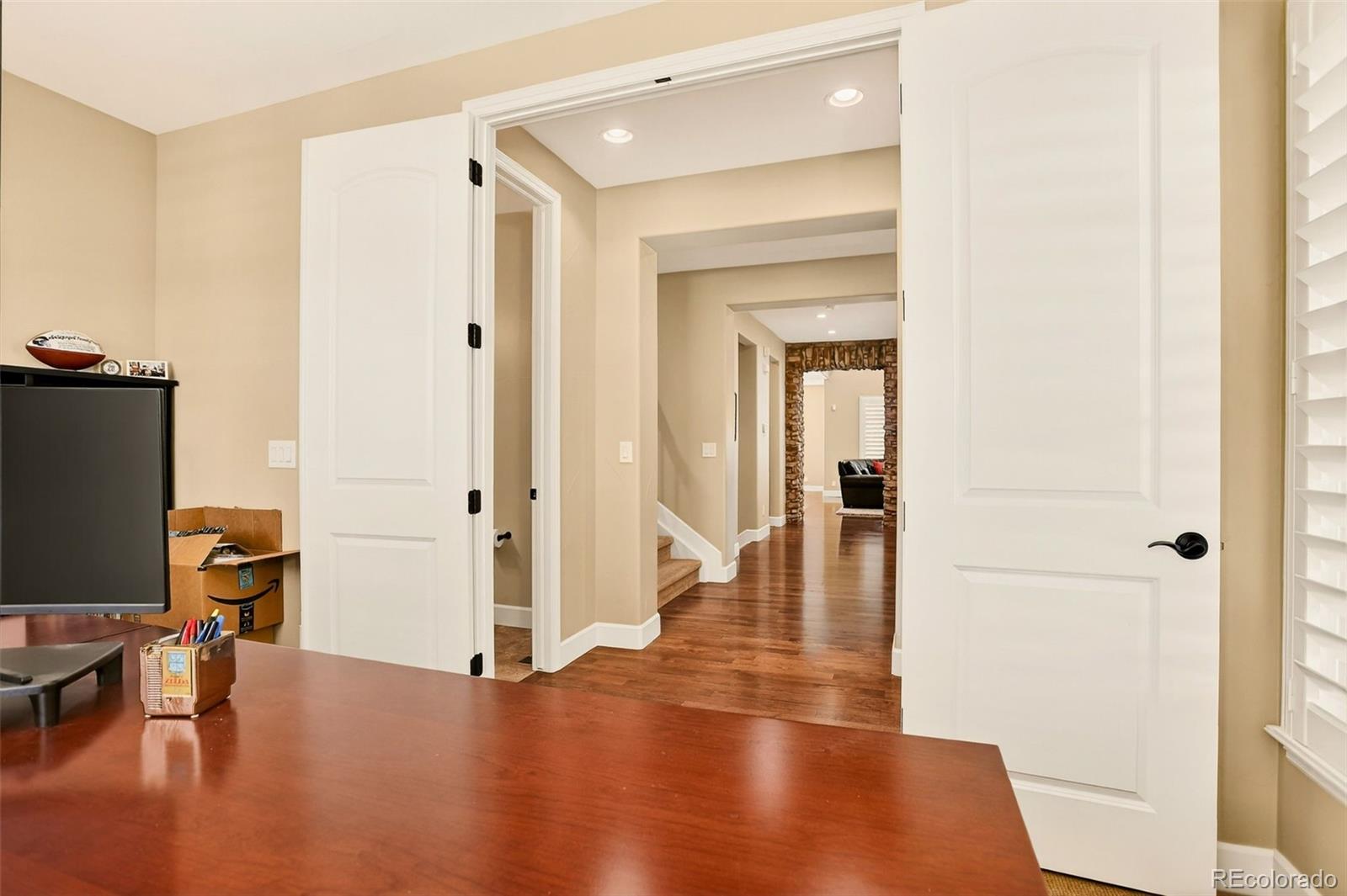 10544 Soulmark Way Highlands Ranch, CO 80126 - Photo 6 of 50 a view of a hallway with wooden floor and furniture