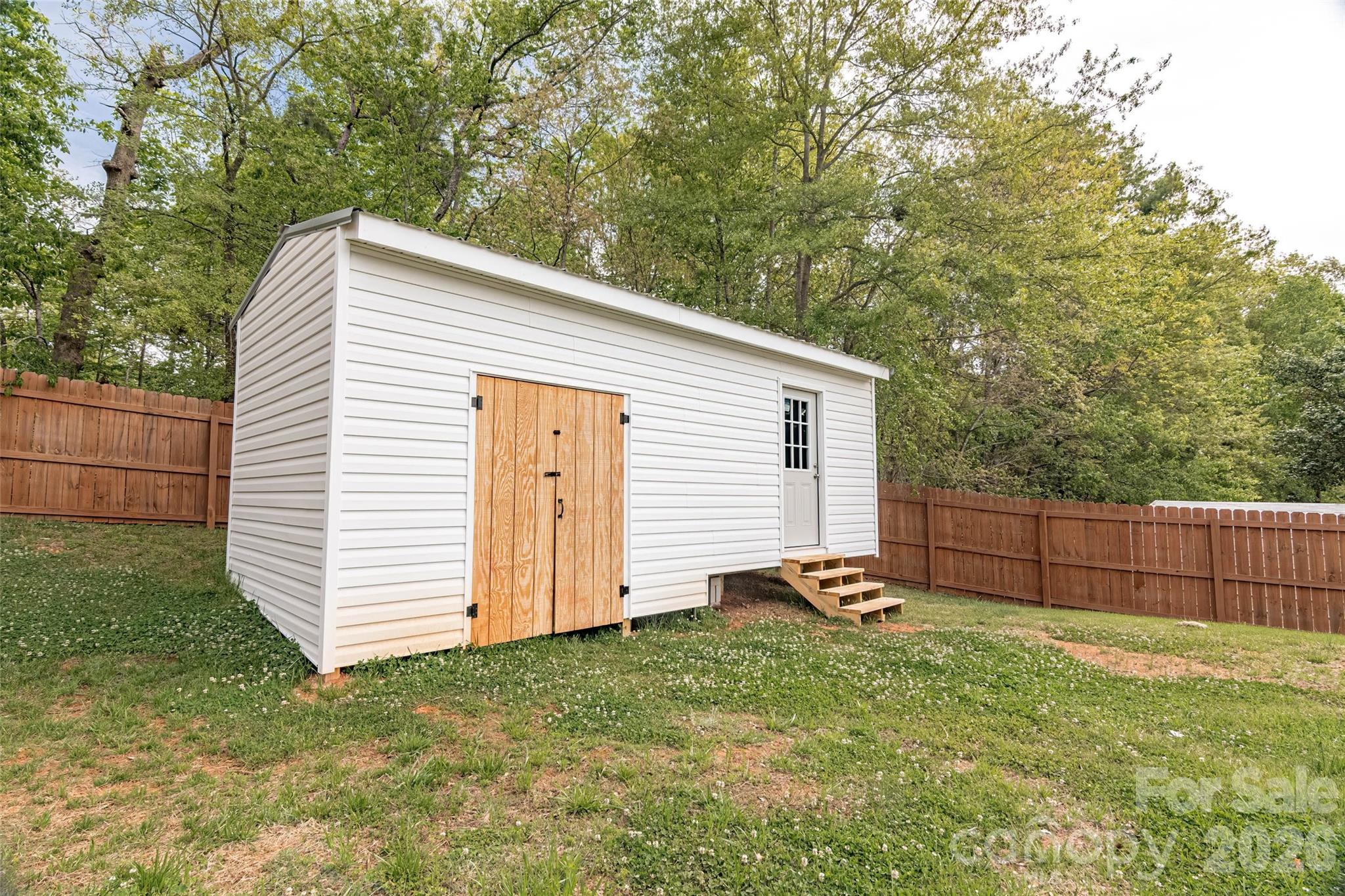 445 Old Caroleen Road Forest City, NC 28043 - Photo 21 of 28 a backyard of a house with wooden fence and large trees