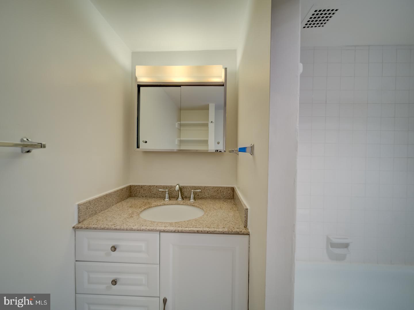 2059 Huntington Avenue, Unit 300 Alexandria, VA 22303 - Photo 15 of 30 a bathroom with a granite countertop sink and a mirror