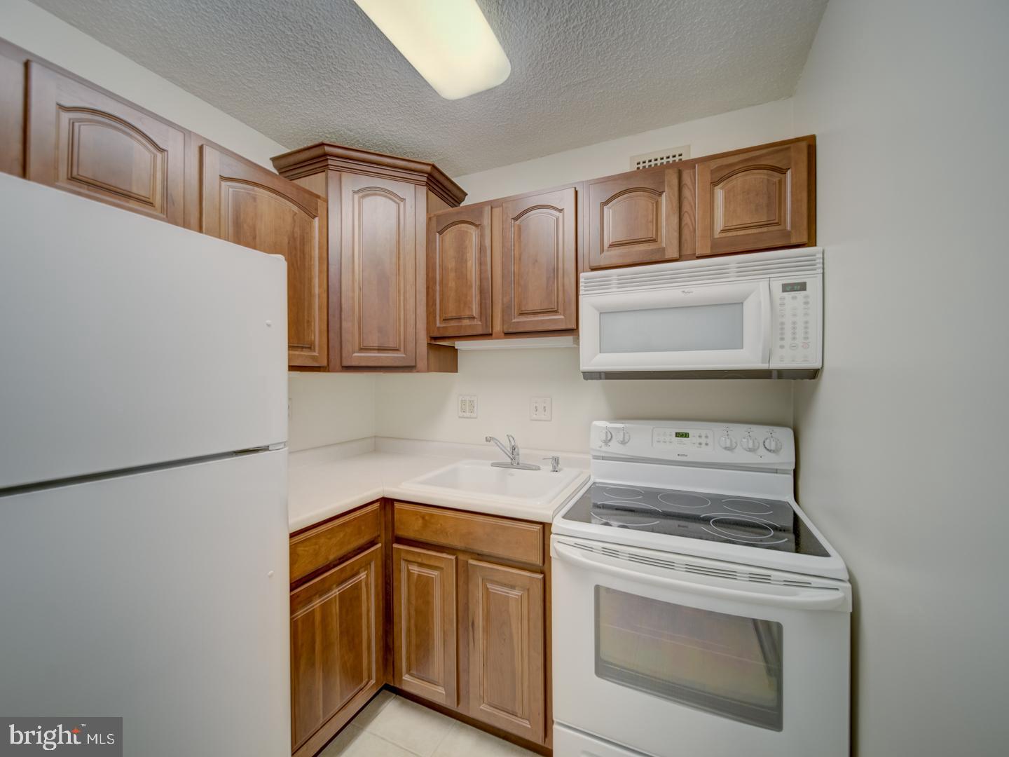 2059 Huntington Avenue, Unit 300 Alexandria, VA 22303 - Photo 9 of 30 a kitchen with stainless steel appliances granite countertop white cabinets stove top oven and sink