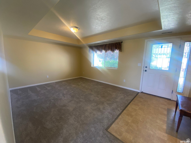 83 Canterbury Circle Logan, UT 84321 - Photo 7 of 23 Foyer entrance featuring a tray ceiling and dark flooring