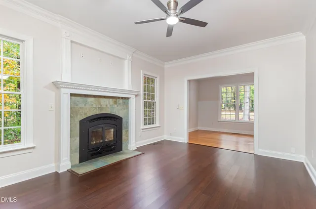 a view of a livingroom with a fireplace wooden floor and windows