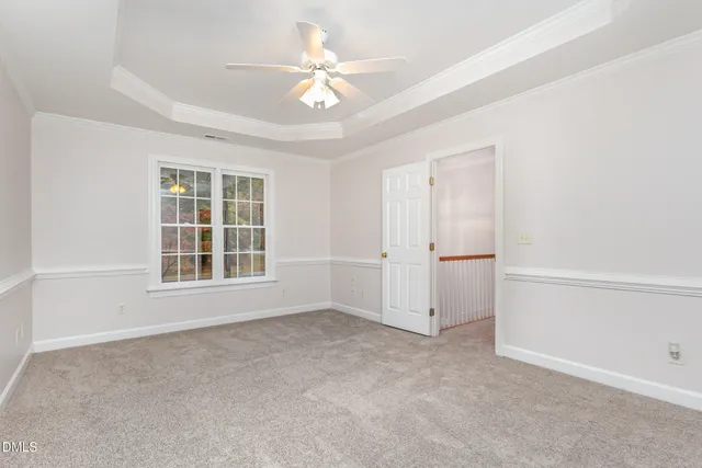 an empty room with windows and ceiling fan