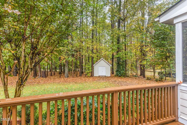 a view of a house with a yard and large trees