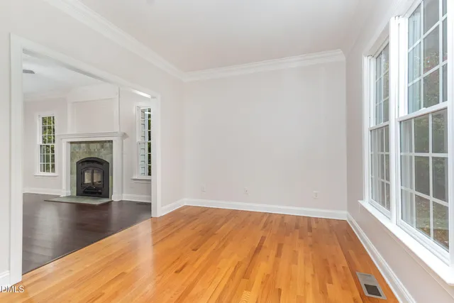 a view of empty room with wooden floor and fireplace