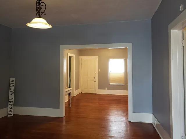 a view of a hallway with wooden floor and a window