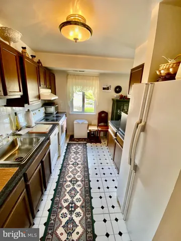 a kitchen with stainless steel appliances a stove a sink a refrigerator and a microwave