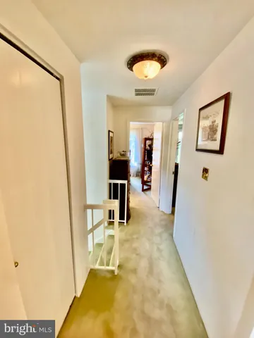 a view of a hallway with furniture and floor to ceiling window