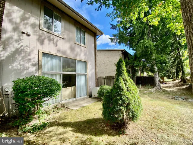 a front view of a house with a yard and potted plants