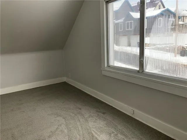 a view of a small space with wooden floor and a window