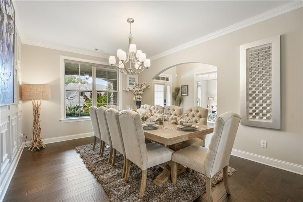 4450 Woodward Walk Lane Suwanee, GA 30024 - Photo 12 of 52 a view of a dining room with furniture wooden floor and chandelier