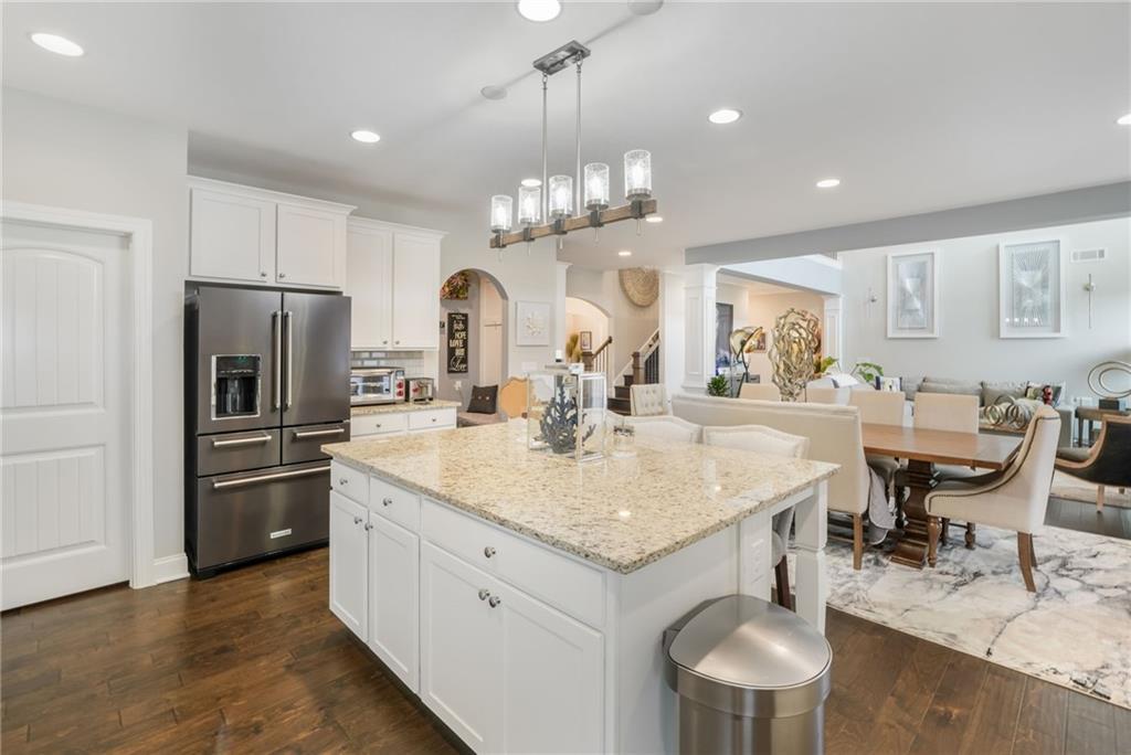 4450 Woodward Walk Lane Suwanee, GA 30024 - Photo 21 of 52 a kitchen with stainless steel appliances granite countertop a kitchen island a stove a table and chairs