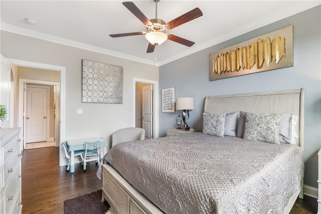 4450 Woodward Walk Lane Suwanee, GA 30024 - Photo 24 of 52 a bedroom with a bed and a chandelier