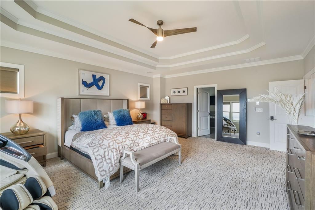 4450 Woodward Walk Lane Suwanee, GA 30024 - Photo 30 of 52 a bedroom with a large bed and a chandelier