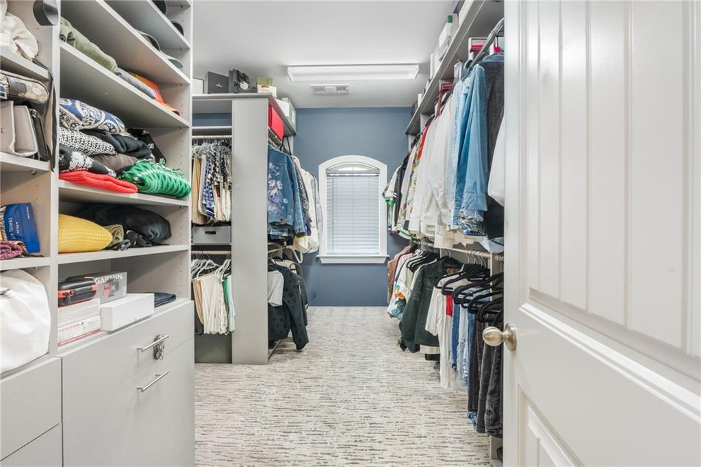 4450 Woodward Walk Lane Suwanee, GA 30024 - Photo 34 of 52 a view of walk in closet with clothes and shoes