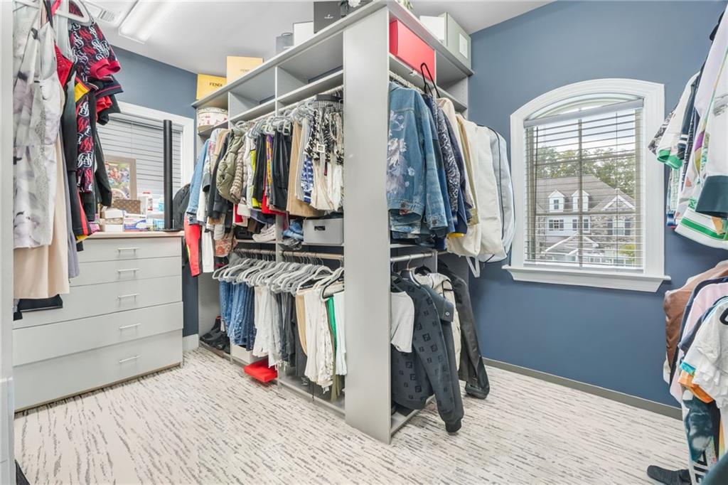 4450 Woodward Walk Lane Suwanee, GA 30024 - Photo 35 of 52 a view of walk in closet with clothes and shoes