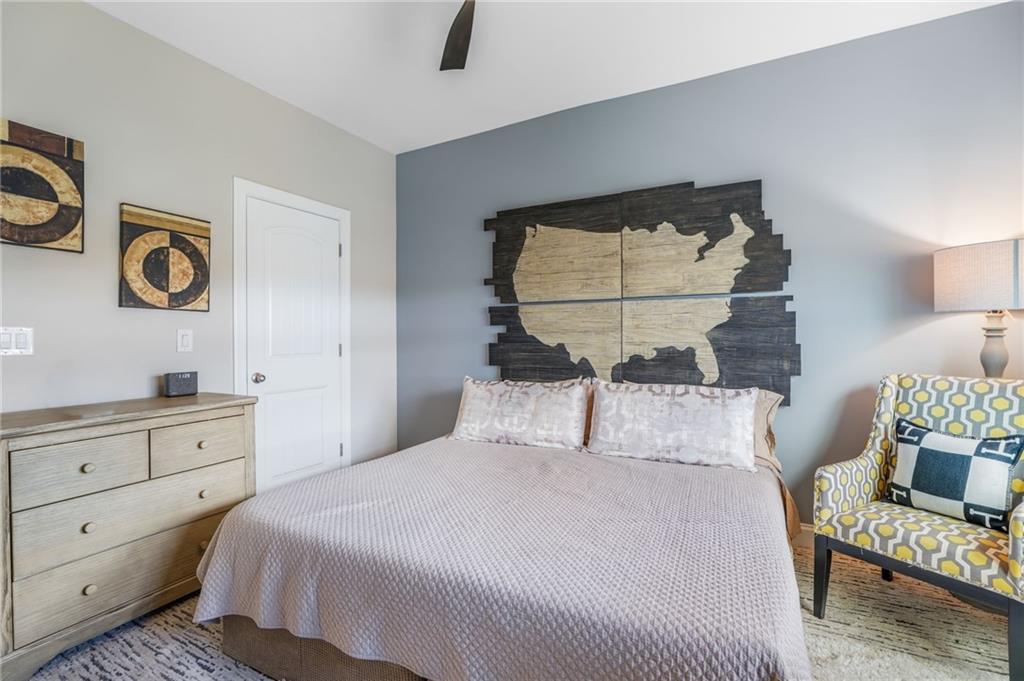 4450 Woodward Walk Lane Suwanee, GA 30024 - Photo 38 of 52 a bedroom with a bed and a lamp on dresser