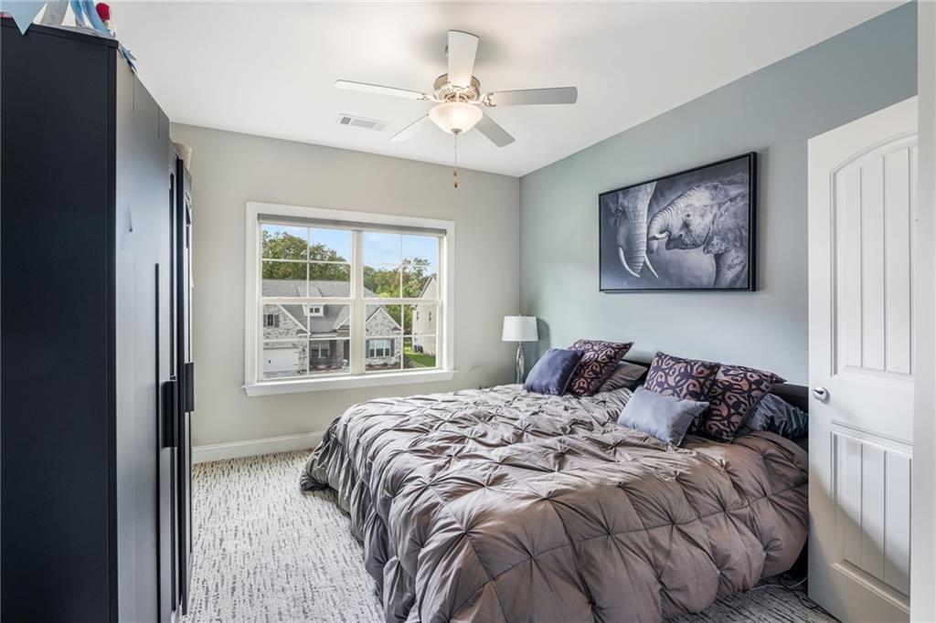 4450 Woodward Walk Lane Suwanee, GA 30024 - Photo 39 of 52 a bedroom with a large bed and a window