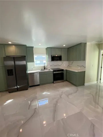 a large kitchen with a stove a refrigerator and a sink