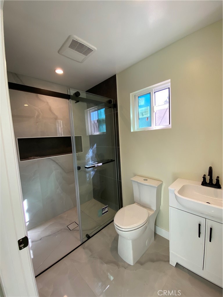 18020 Welby Reseda, CA 91335 - Photo 11 of 16 a bathroom with a toilet a sink and mirror