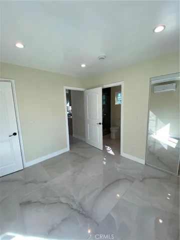 an empty room with an entryway and closet area