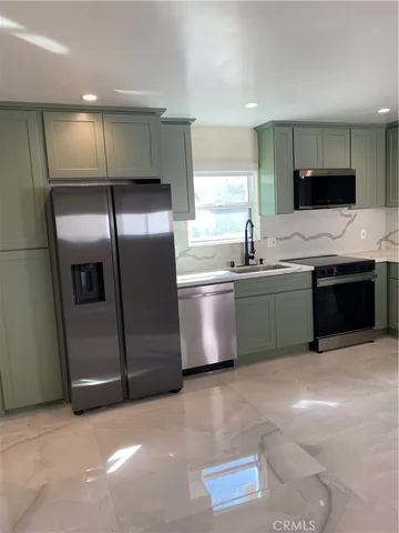 a kitchen with stainless steel appliances a sink and a refrigerator