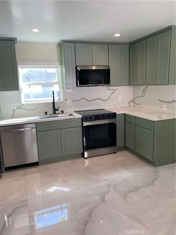 a kitchen with stainless steel appliances granite countertop a sink and a stove