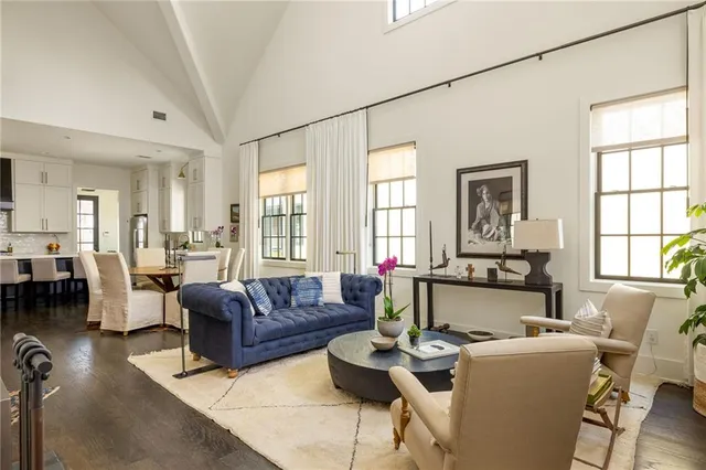a living room with fireplace furniture and floor to ceiling windows