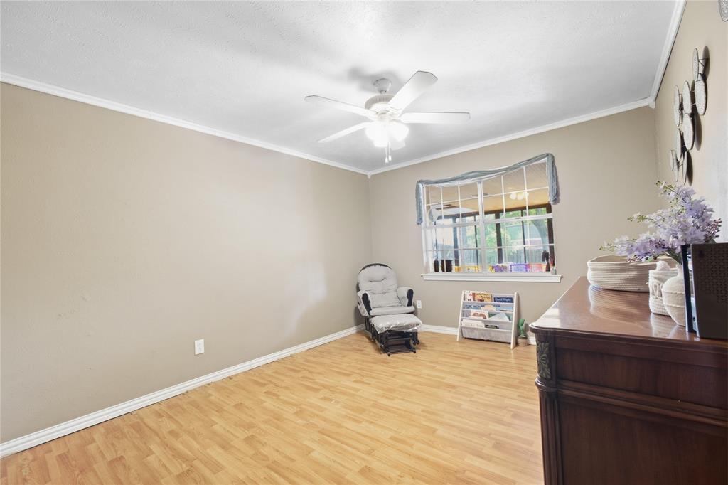 1320 Cheyenne Road Lewisville, TX 75077 - Photo 19 of 27 Wood-finish flooring with neutral wall paint, crown molding, and a ceiling fan with integrated lighting