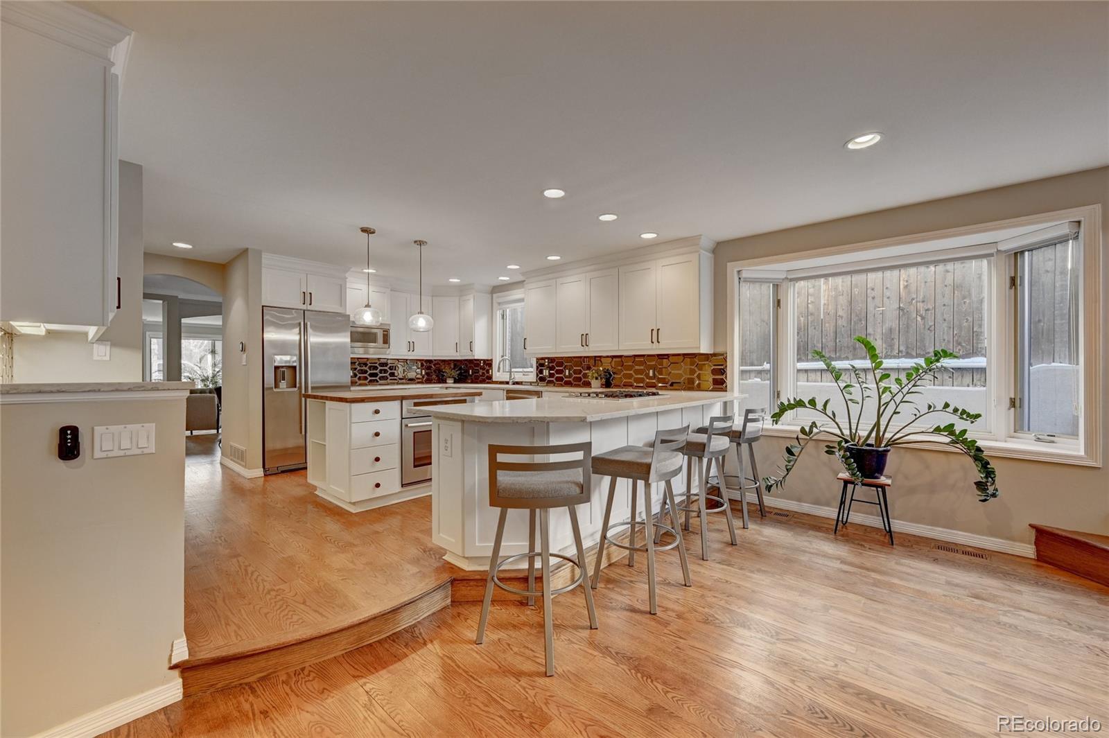 358 Steele Street Denver, CO 80206 - Photo 11 of 30 a living room with stainless steel appliances kitchen island granite countertop furniture and a wooden floor